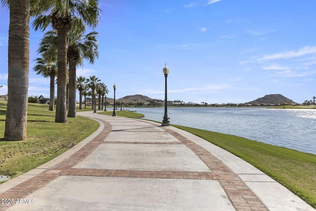 surrounding community with a yard and a water and mountain view