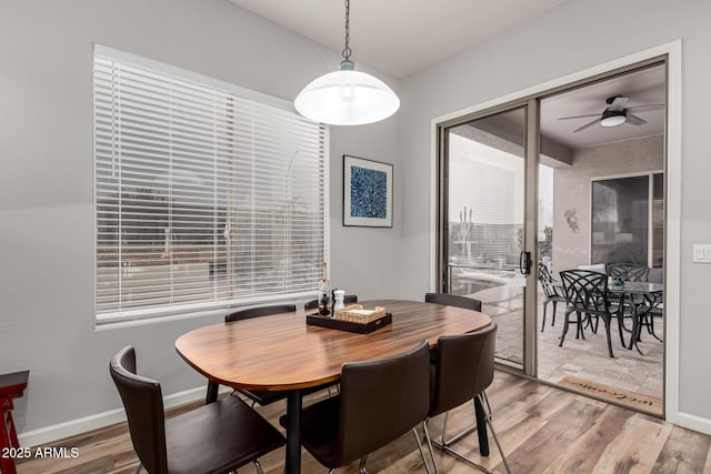 dining space featuring ceiling fan, light wood-type flooring, and baseboards