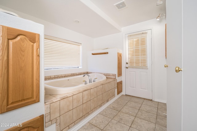 bathroom featuring tile patterned floors and a relaxing tiled tub