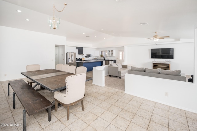 dining area featuring vaulted ceiling, ceiling fan with notable chandelier, and light tile patterned floors