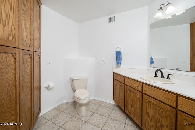 bathroom featuring vanity, tile patterned flooring, and toilet