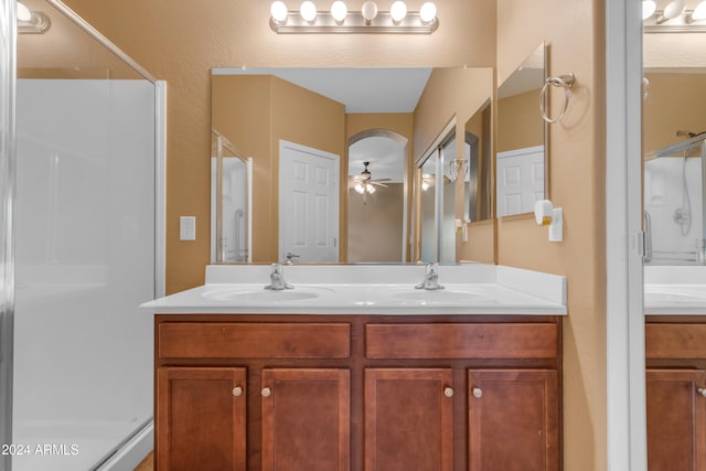 bathroom featuring a shower with door, vanity, and ceiling fan