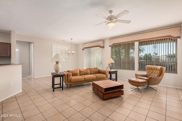 tiled living room featuring ceiling fan with notable chandelier