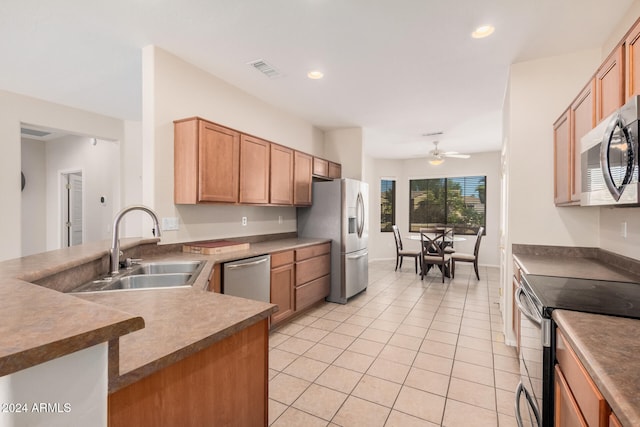 kitchen featuring kitchen peninsula, sink, light tile patterned floors, ceiling fan, and appliances with stainless steel finishes