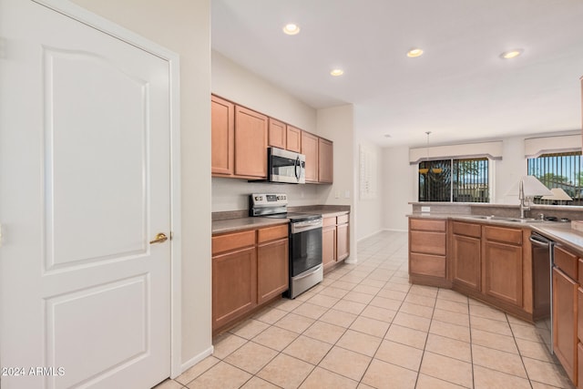 kitchen with stainless steel appliances, sink, decorative light fixtures, and light tile patterned floors