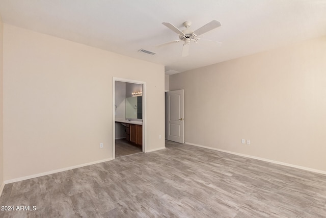 unfurnished bedroom with light hardwood / wood-style flooring, ceiling fan, and ensuite bath