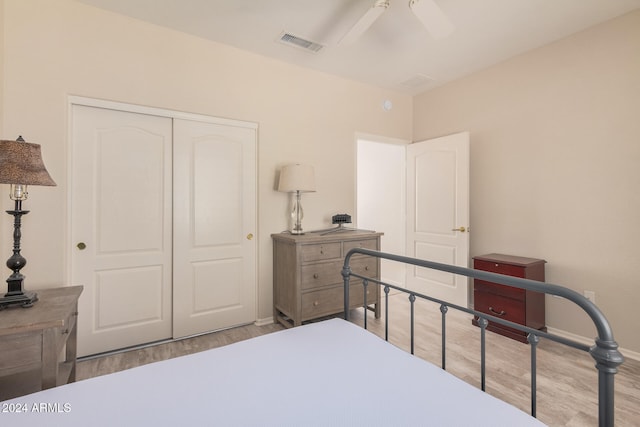 bedroom with light hardwood / wood-style floors, ceiling fan, and a closet