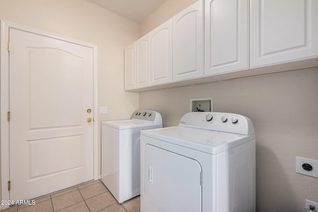 washroom featuring cabinets, light tile patterned floors, and washer and dryer