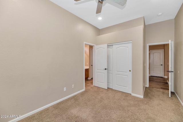 unfurnished bedroom featuring ceiling fan, a closet, and light colored carpet