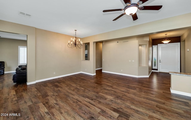 spare room with dark hardwood / wood-style floors and ceiling fan with notable chandelier