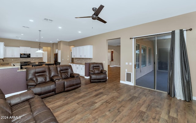 living room with hardwood / wood-style floors, ceiling fan, and sink