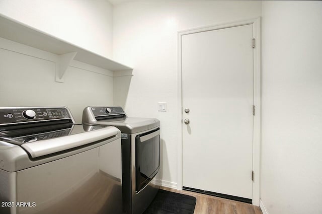 laundry room featuring independent washer and dryer and light hardwood / wood-style flooring