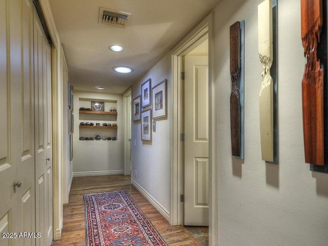 corridor with wood-type flooring