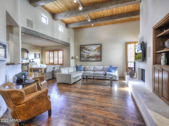 living room featuring wood ceiling, a towering ceiling, dark hardwood / wood-style floors, track lighting, and beamed ceiling