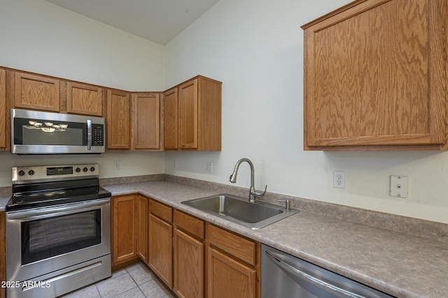 kitchen with stainless steel appliances, sink, and light tile patterned floors