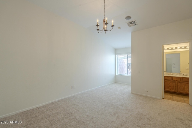 carpeted spare room featuring a notable chandelier