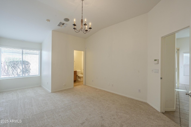 empty room with vaulted ceiling, light colored carpet, and an inviting chandelier