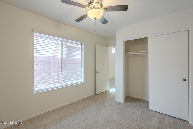 unfurnished bedroom with ceiling fan, light colored carpet, and a closet