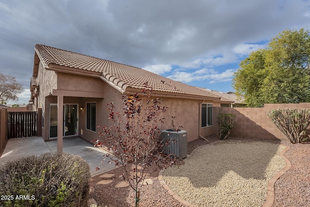 rear view of house with a patio and central AC unit