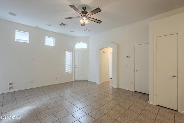 tiled spare room featuring ceiling fan