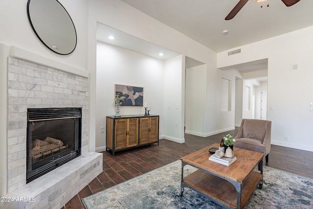 living room with a brick fireplace, dark hardwood / wood-style floors, and ceiling fan