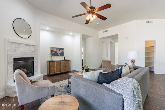 living room with ceiling fan, a brick fireplace, and dark hardwood / wood-style floors