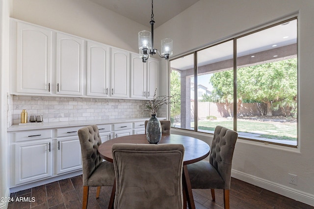 dining space featuring an inviting chandelier, dark hardwood / wood-style floors, and vaulted ceiling