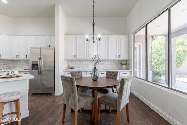 dining space with a chandelier and dark hardwood / wood-style flooring