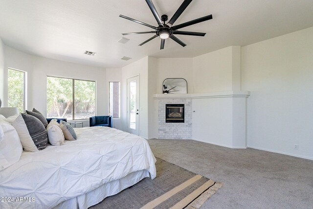 bedroom with carpet flooring, ceiling fan, and a brick fireplace