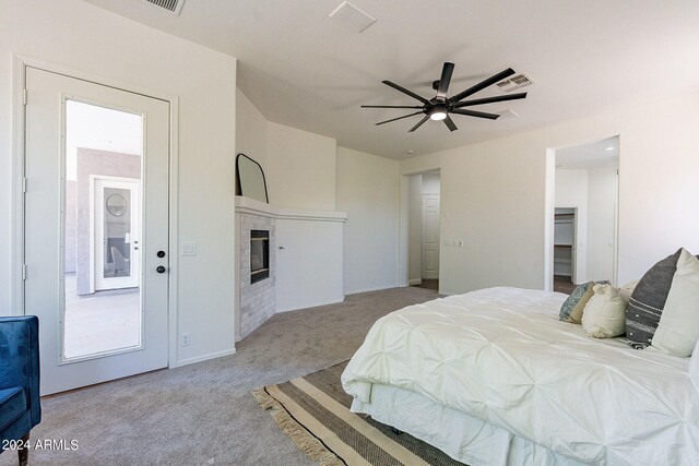 carpeted bedroom with a spacious closet, ceiling fan, and a closet