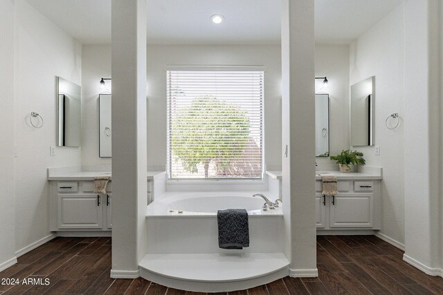 bathroom featuring a tub to relax in, hardwood / wood-style flooring, vanity, and a wealth of natural light