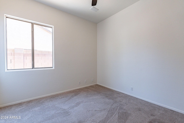 carpeted spare room featuring ceiling fan