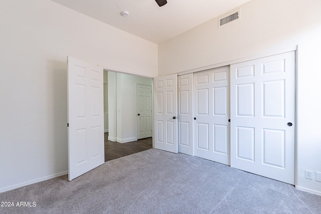 unfurnished bedroom with dark carpet, a closet, and ceiling fan