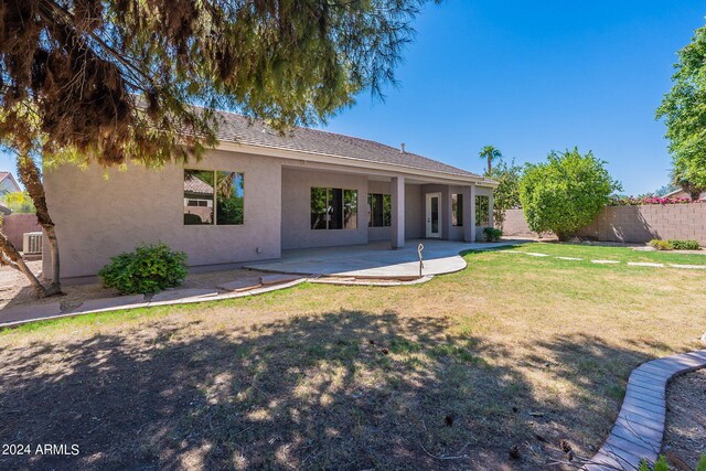 back of property with a patio and a yard