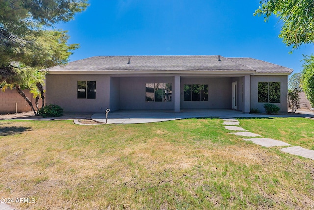 rear view of house featuring a patio and a yard