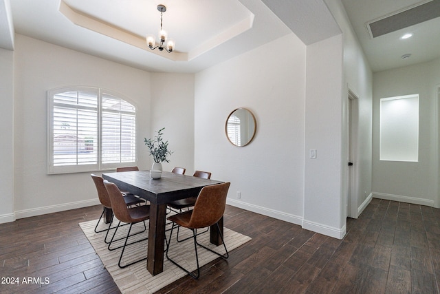 dining room featuring a tray ceiling and dark hardwood / wood-style floors