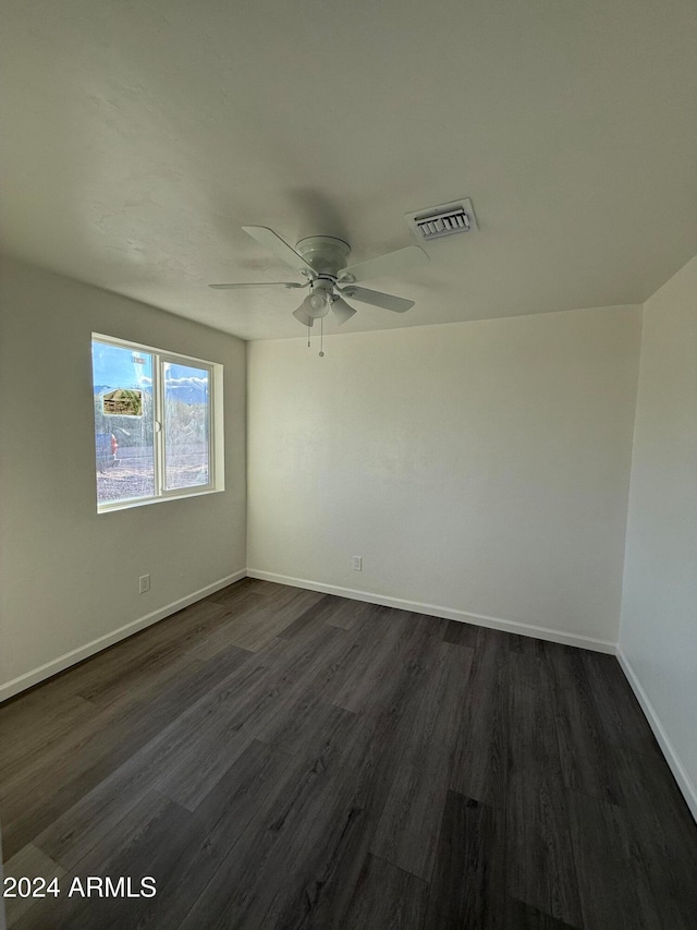 spare room featuring dark wood-type flooring and ceiling fan