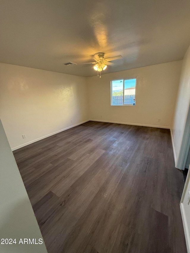 unfurnished room with dark wood-type flooring and ceiling fan