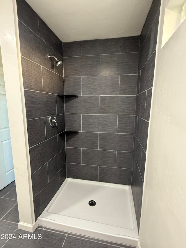 bathroom with tile patterned flooring and tiled shower