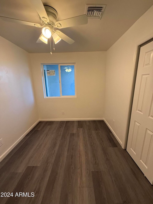 empty room featuring dark wood-type flooring and ceiling fan