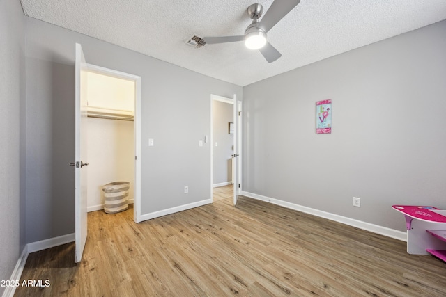 bedroom featuring a textured ceiling, ceiling fan, and light hardwood / wood-style flooring