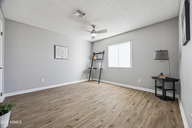 unfurnished bedroom featuring ceiling fan, a textured ceiling, and light wood-type flooring