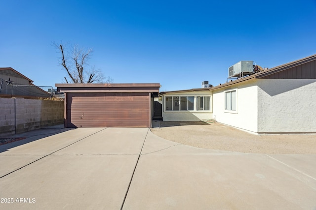 view of front of home featuring a garage and central air condition unit