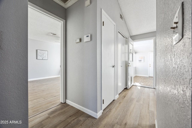 hallway featuring a textured ceiling and light wood-type flooring