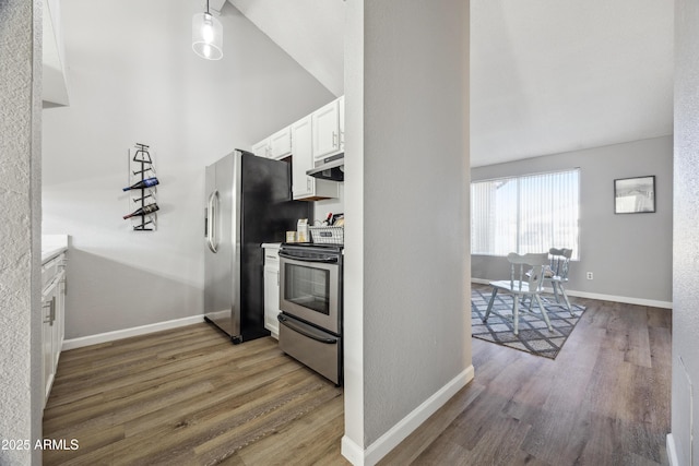 kitchen with stainless steel appliances, white cabinetry, vaulted ceiling, and dark hardwood / wood-style flooring