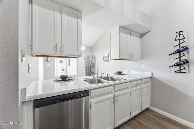 kitchen featuring hardwood / wood-style flooring, sink, stainless steel dishwasher, and white cabinets