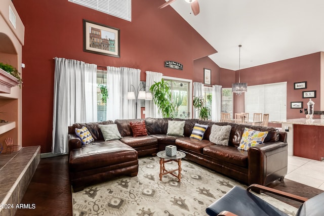 living room featuring a high ceiling, ceiling fan, a wealth of natural light, and wood-type flooring