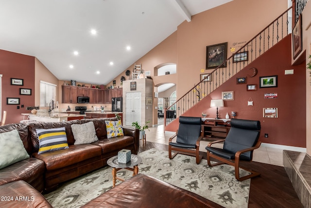 living room featuring sink, high vaulted ceiling, and light hardwood / wood-style floors