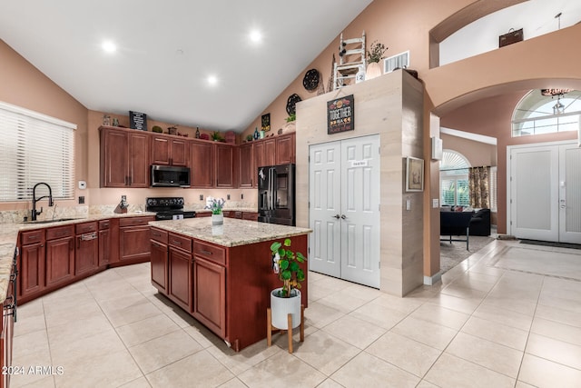 kitchen with a kitchen island, black appliances, sink, high vaulted ceiling, and light stone counters