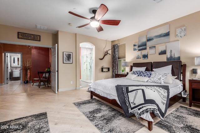 bedroom with ensuite bath, ceiling fan, and light hardwood / wood-style floors